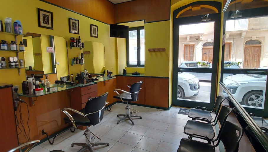 Interior of IX-XUXA Barbers in Il-gżira, MT, featuring modern chairs, mirrors, and stylish decor.