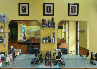 Modern interior of IX-XUXA Barbers in Il-gżira, MT with grooming products on a stylish shelf.