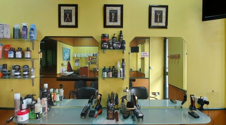 Modern interior of IX-XUXA Barbers in Il-gżira, MT with grooming products on a stylish shelf.