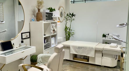 Spa room at SOLACE SPA, Miami, Florida, US, featuring a sleek design with white decor and plush seating.