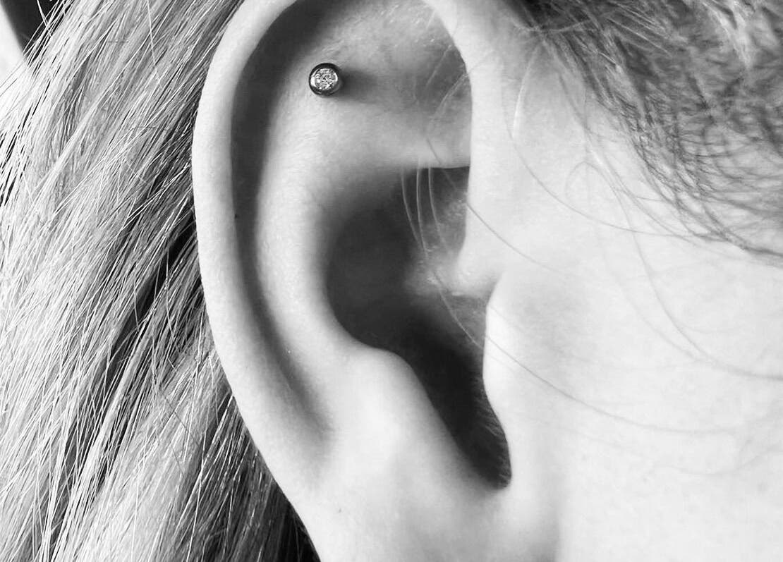 Elegant ear piercing with a sparkling gem at Thy Eternal, Hayle, England, GB.