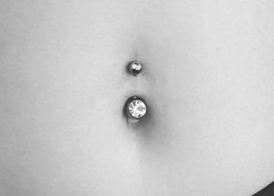 Stylish belly button piercing at Thy Eternal, Hayle, England, GB, showcased in monochrome detail.