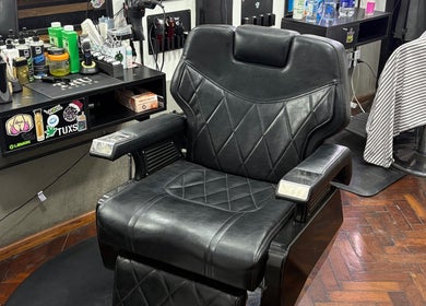 Interior de Salto Barbería, Villa Lugano, destacando una silla de barbería elegante y profesional.