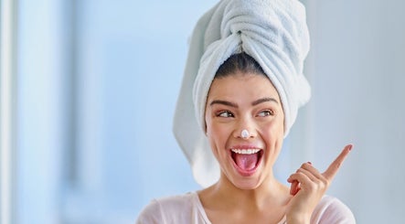 Happy woman with face mask smiling at Salon Antoine, Potchefstroom, North West, ZA.