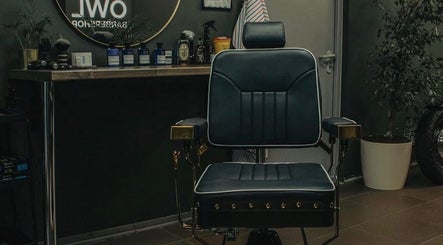 Stylish barber chair at OWL Barbershop, Rīga, LV, showcasing a modern, inviting grooming atmosphere.