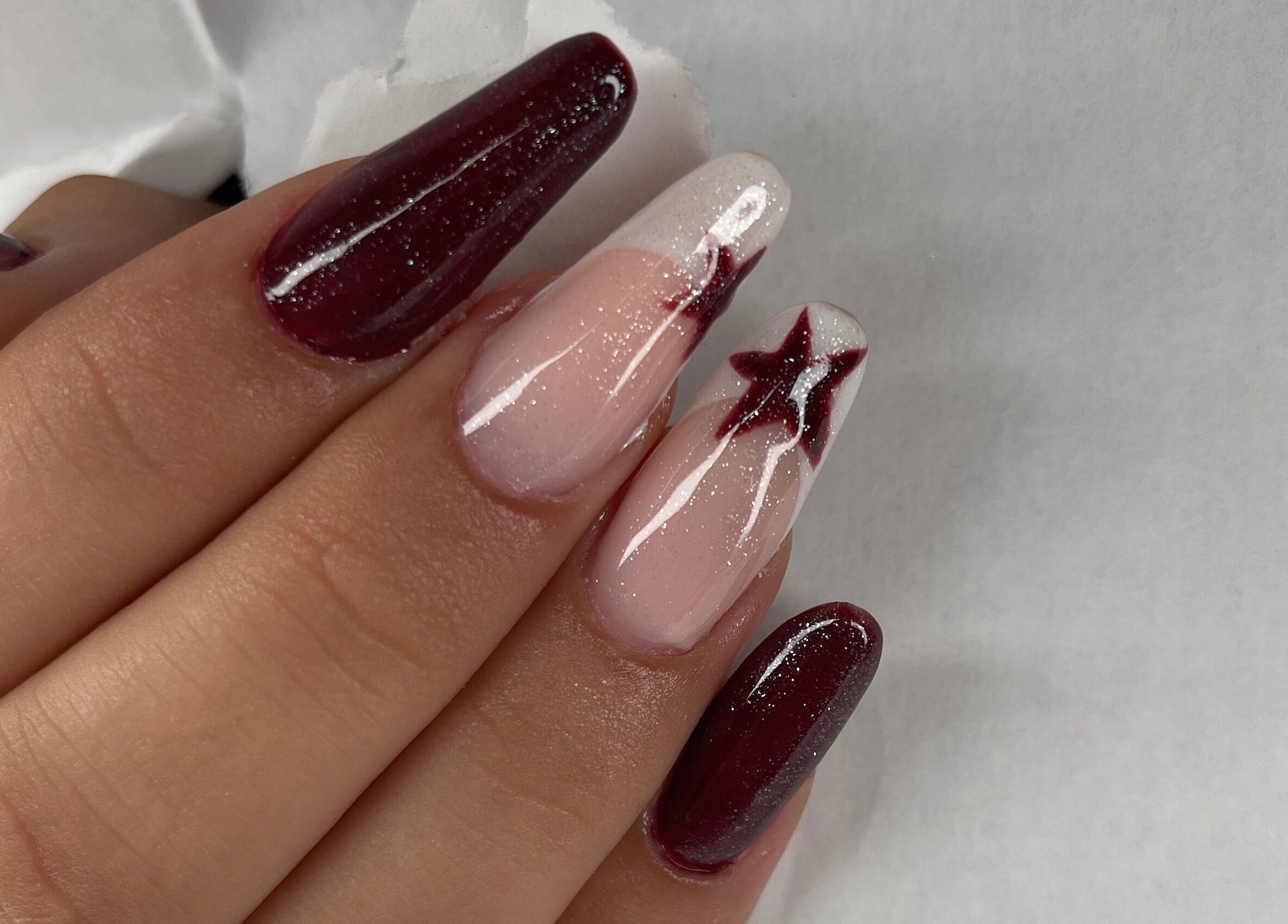 Nail art étoilé élégant chez Run Nails D, Mussidan, Nouvelle-aquitaine, FR. Vernis bordeaux et paillettes.