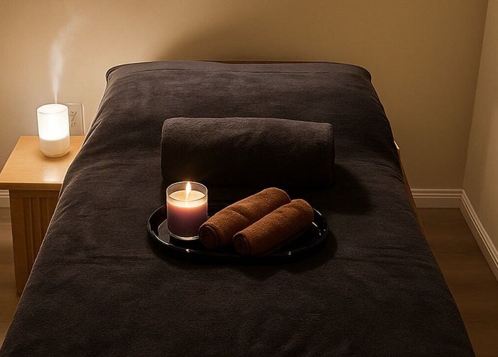 Relaxing massage room at Massage Legendary, Taigum, Queensland, AU with candles and rolled towels on a bed.