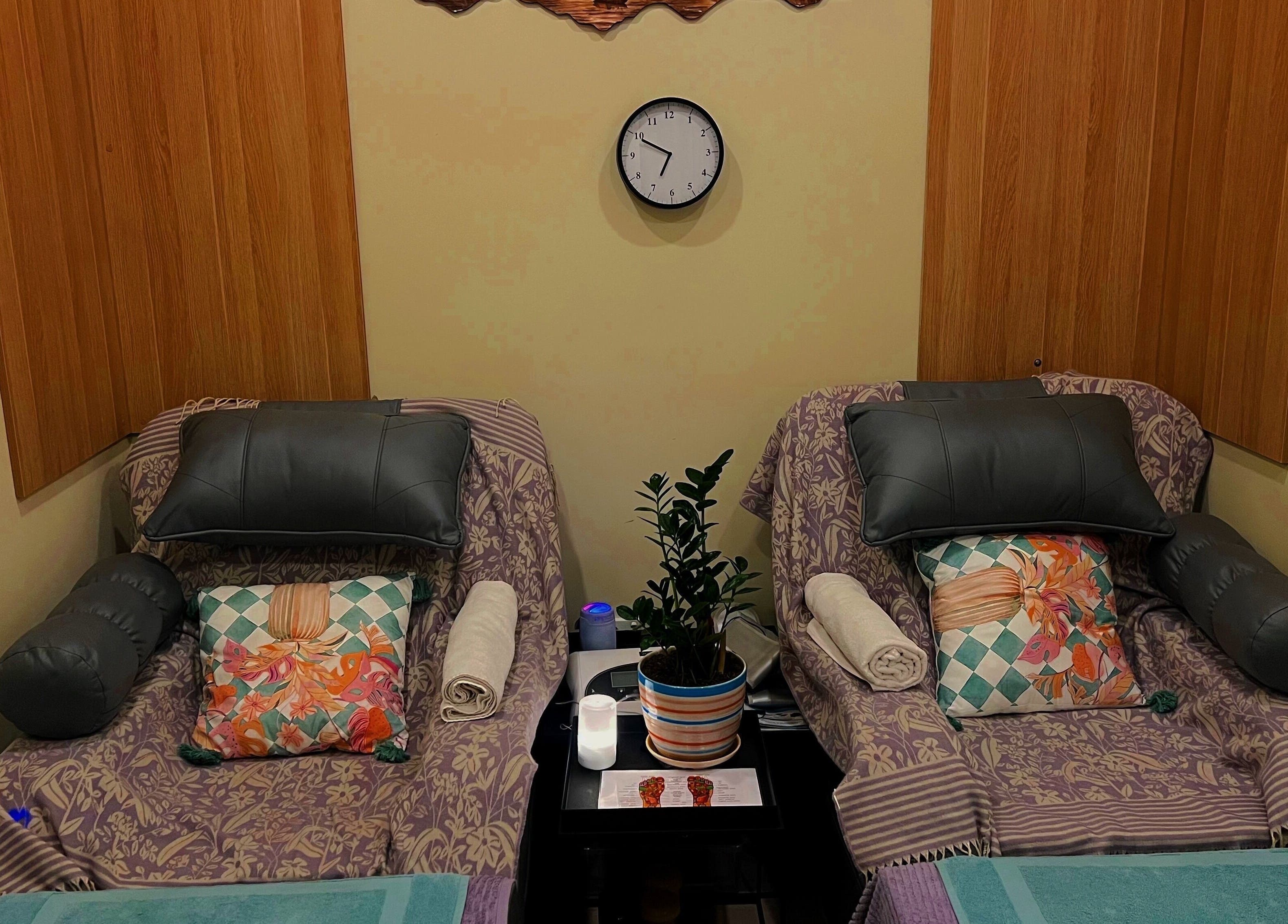 Cozy massage chairs at Massage Legendary in Taigum, Queensland, AU, featuring vibrant pillows and calming decor.