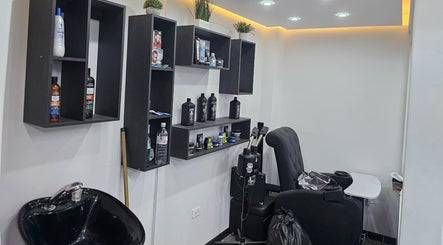 Interior moderno de Lest Barber Club, Tuluá, Valle Del Cauca, CO, con silla de barbería y estantería elegante.