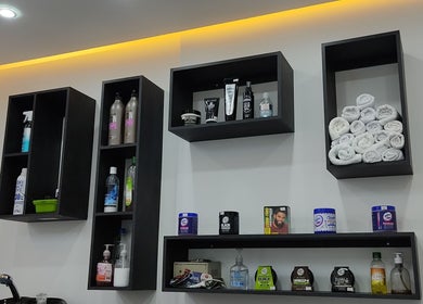 Estantes con productos de belleza y toallas en Lest Barber Club, Tuluá, Valle Del Cauca, CO.