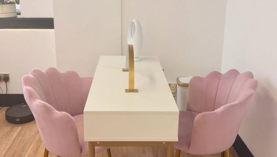 Elegant nail salon setup at Nailed It Sis, Stafford, England, GB with pink chairs and a modern desk.