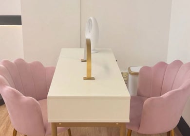 Elegant nail salon setup at Nailed It Sis, Stafford, England, GB with pink chairs and a modern desk.