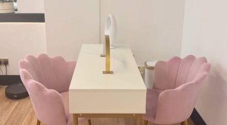 Elegant nail salon setup at Nailed It Sis, Stafford, England, GB with pink chairs and a modern desk.