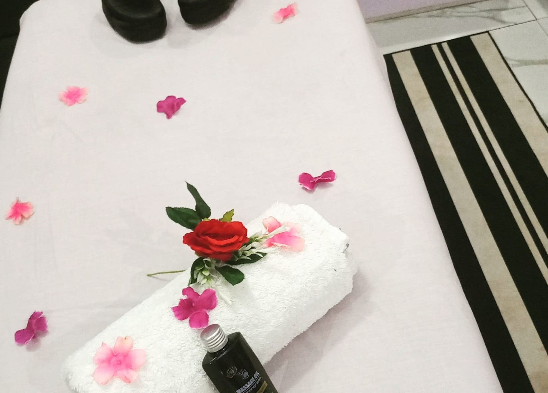 Massage table at Damme's Wellness in Lagos, Lagos, NG, adorned with flowers and oils for a calming experience.