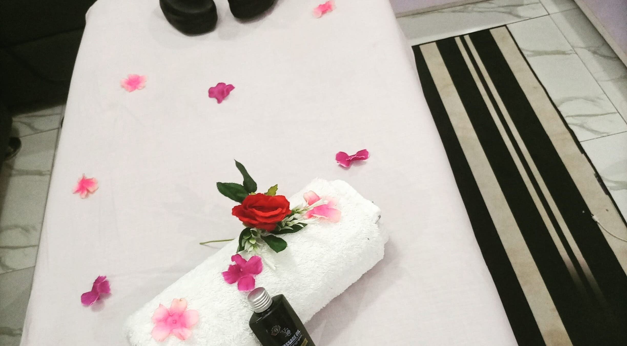Massage table at Damme's Wellness in Lagos, Lagos, NG, adorned with flowers and oils for a calming experience.