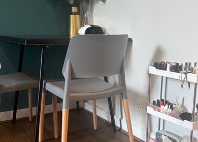 Cozy nail station at Nailed By Amii, Leeds, England, GB with modern chairs and nail polish display.