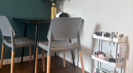 Cozy nail station at Nailed By Amii, Leeds, England, GB with modern chairs and nail polish display.
