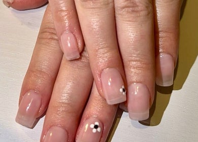 Elegant nude manicure with flower art at Nailed By Amii, Leeds, England, GB, showcasing expert nail design.