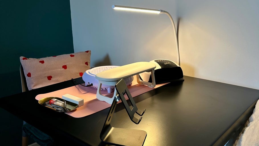 Manicure station at Nailed By Amii, Leeds, England, GB, featuring a lamp and tools on a sleek black table.