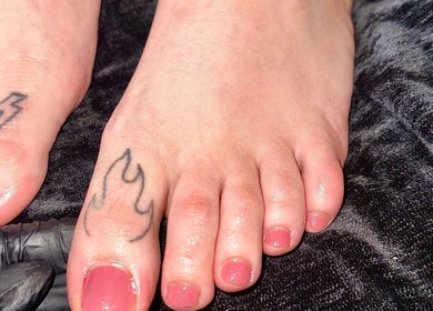 Close-up of tattooed toes with pink polish at Nailed By Amii, Leeds, England, GB.