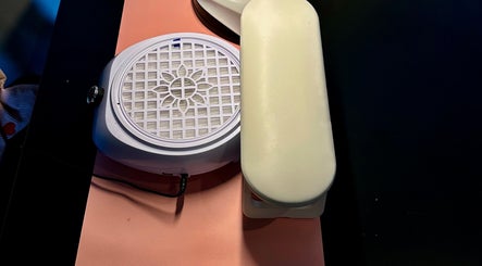 Nail station at Nailed By Amii, Leeds, England, GB, showcasing manicure tools and cushioned armrest.