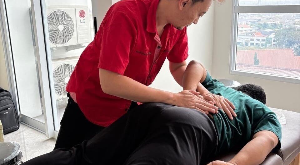 Terapis di PH Remedial Massage - Surabaya, Jawa Timur, memberikan perawatan pijat profesional di meja pijat.