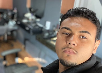 Interior moderno da DM barbearia em Minas Gerais, Minas Gerais, BR, mostrando uma cadeira e um profissional.