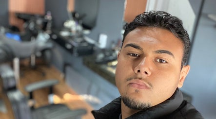 Interior moderno da DM barbearia em Minas Gerais, Minas Gerais, BR, mostrando uma cadeira e um profissional.