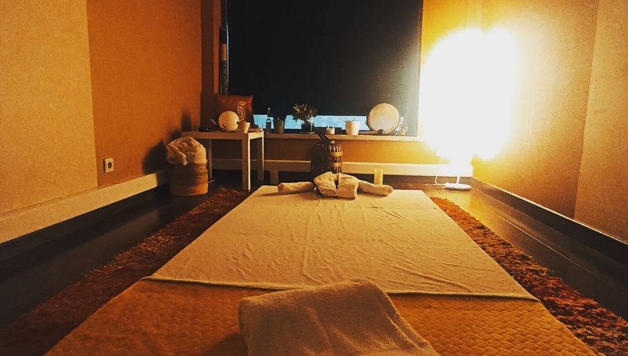 Sala de spa aconchegante no Atlantys, Leiria, Leiria, PT, com iluminação suave e toalhas preparadas.