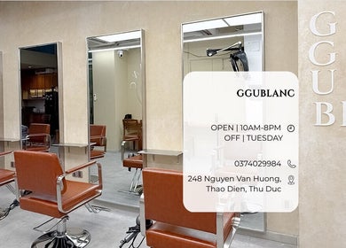 Không gian sang trọng tại Ggublanc Hair, Hồ Chí Minh, Hồ Chí Minh, VN với ghế salon và gương lớn.