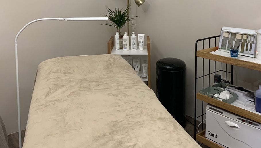 Cozy treatment bed at WildRose Natural Beauty Studio in Fladbury, England, GB, with skincare products displayed.