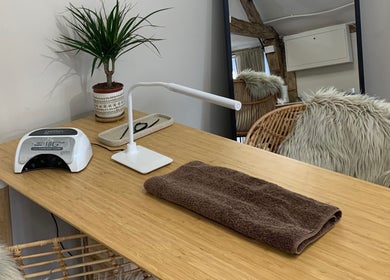 Nail station at WildRose Natural Beauty Studio in Fladbury, England, GB with modern decor and a leafy plant.
