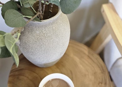 A cozy corner at WildRose Natural Beauty Studio, Fladbury, England, featuring a textured vase and a hot drink.