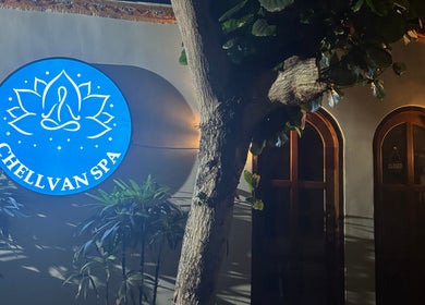 Chellvan_spa entrance with a glowing blue sign surrounded by lush greenery, Bali, Bali, ID.