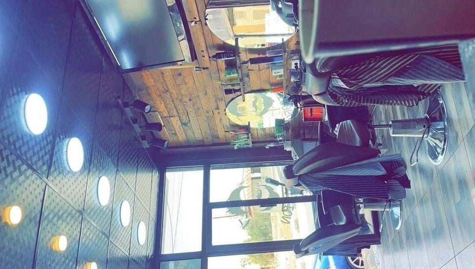 تصميم داخلي عصري في A3 Saloon, السخنة, محافظة الزرقاء, JO يظهر كراسي أنيقة وديكور خشبي.