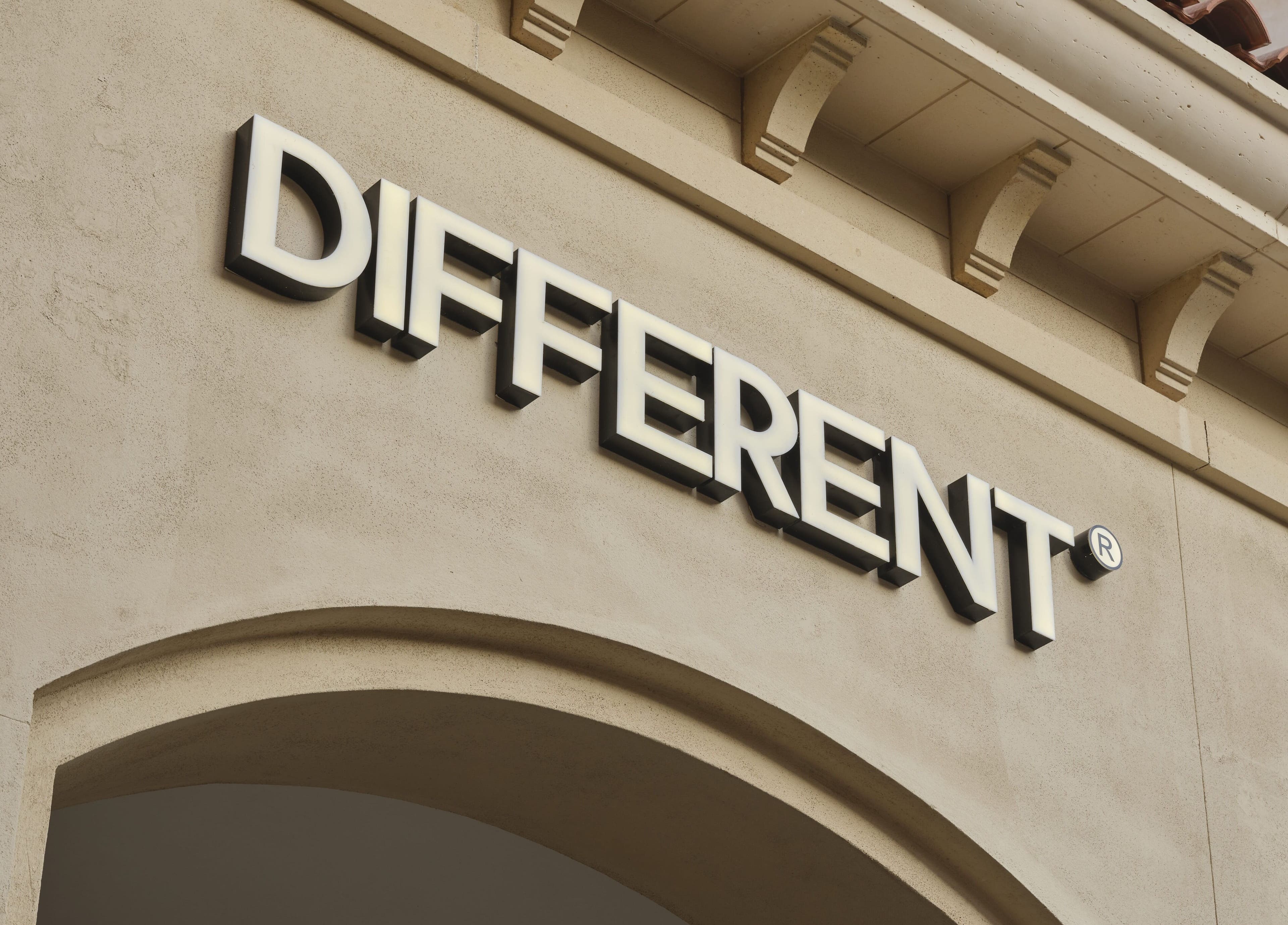 Exterior signage of DIFFERENT Clinic in Abu Dhabi, AE, highlighting its elegant stone facade.