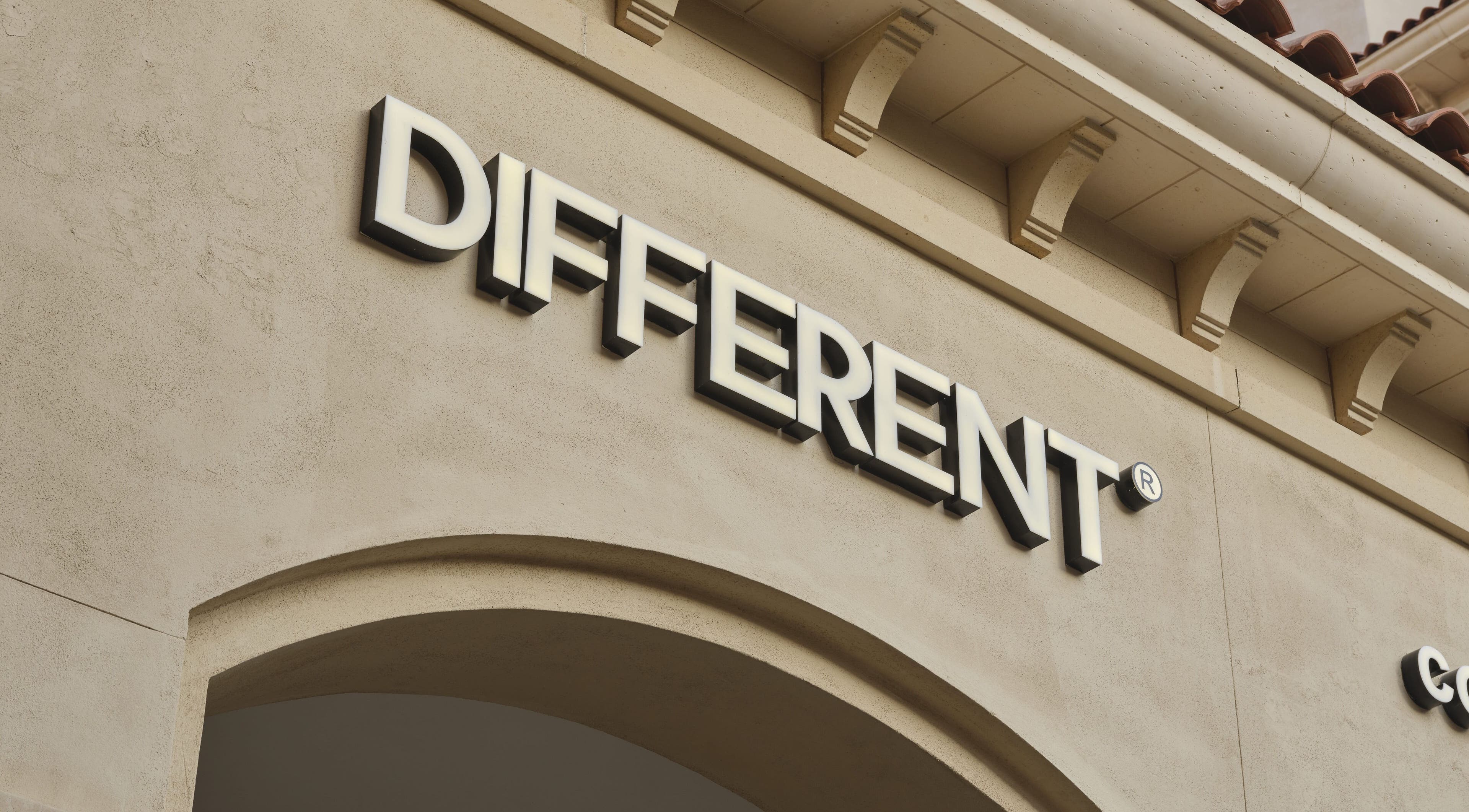 Exterior signage of DIFFERENT Clinic in Abu Dhabi, AE, highlighting its elegant stone facade.