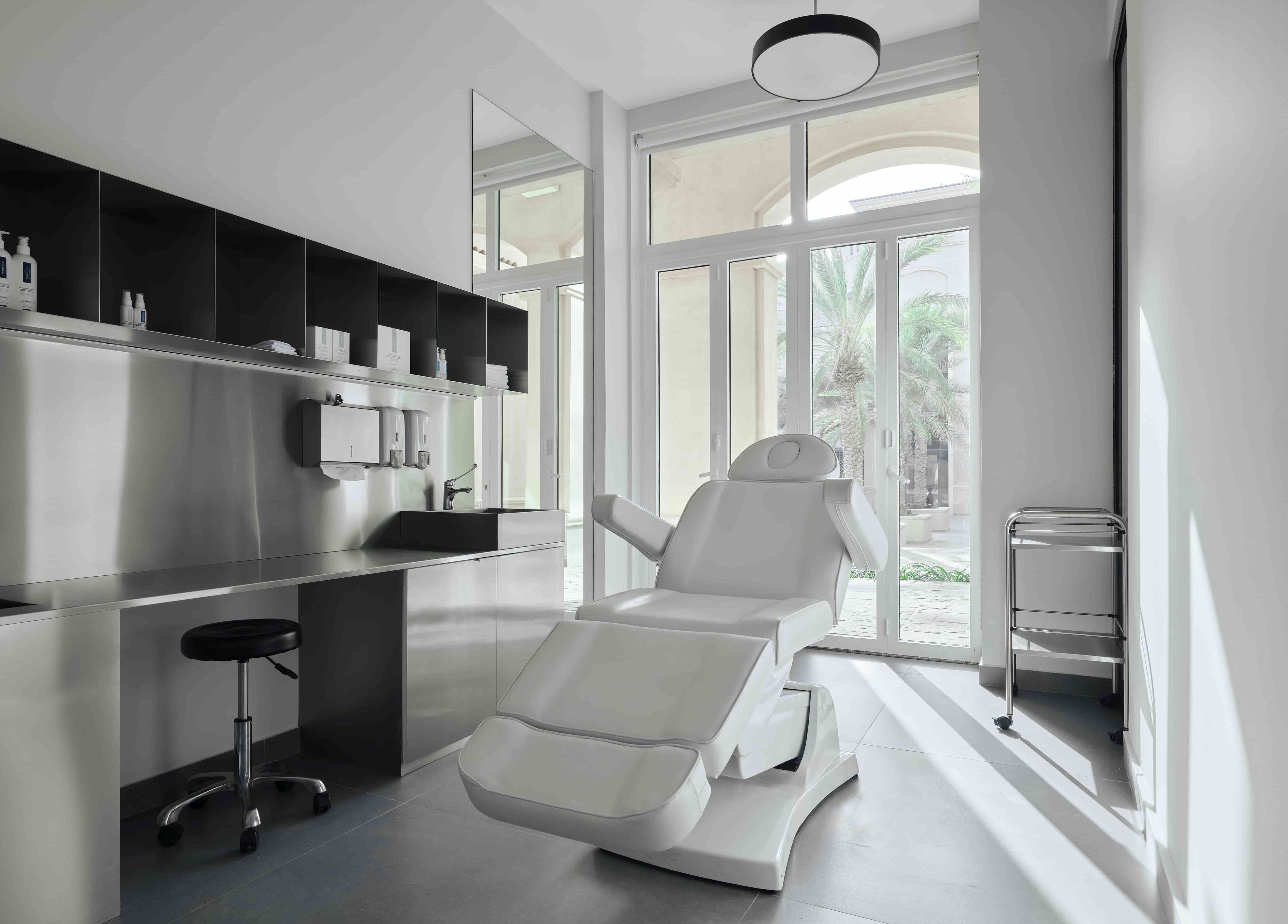 Modern treatment room at DIFFERENT Clinic in Abu Dhabi, Abu Dhabi, AE with a reclined white chair.