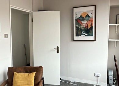 A tranquil room at Palms of Health in London, England, GB, featuring a serene painting and comfortable chair.