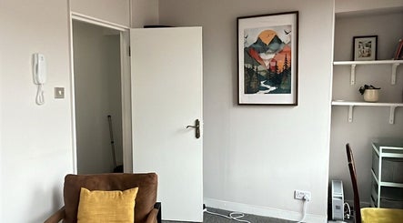 A tranquil room at Palms of Health in London, England, GB, featuring a serene painting and comfortable chair.