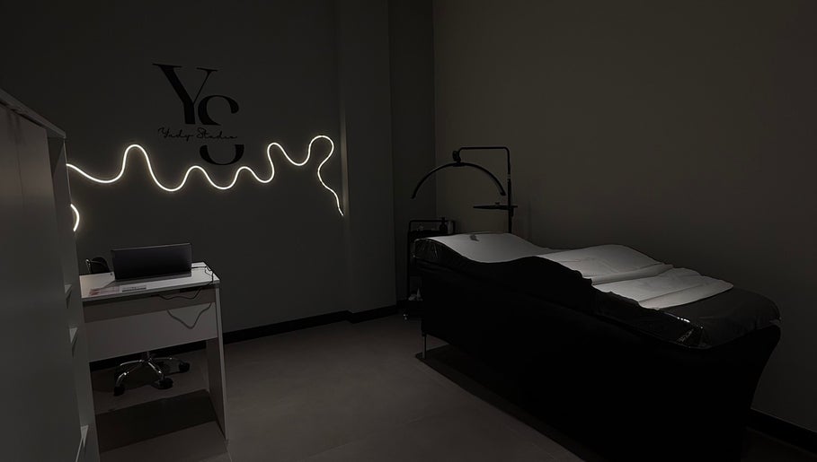 Elegante espacio de tratamiento en Yudy Studio, Madrid, Comunidad De Madrid, ES, con iluminación suave y elegante camilla.