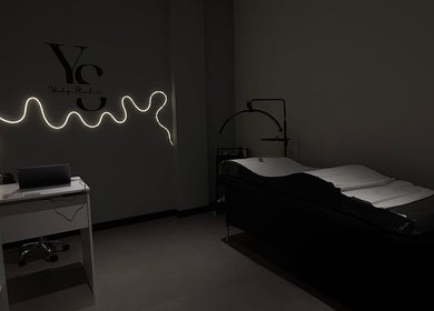 Elegante espacio de tratamiento en Yudy Studio, Madrid, Comunidad De Madrid, ES, con iluminación suave y elegante camilla.