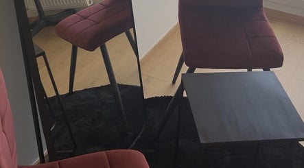 Espace chic avec fauteuil rouge et miroir à GEMSTAVIBE, Muret, Occitanie, FR.