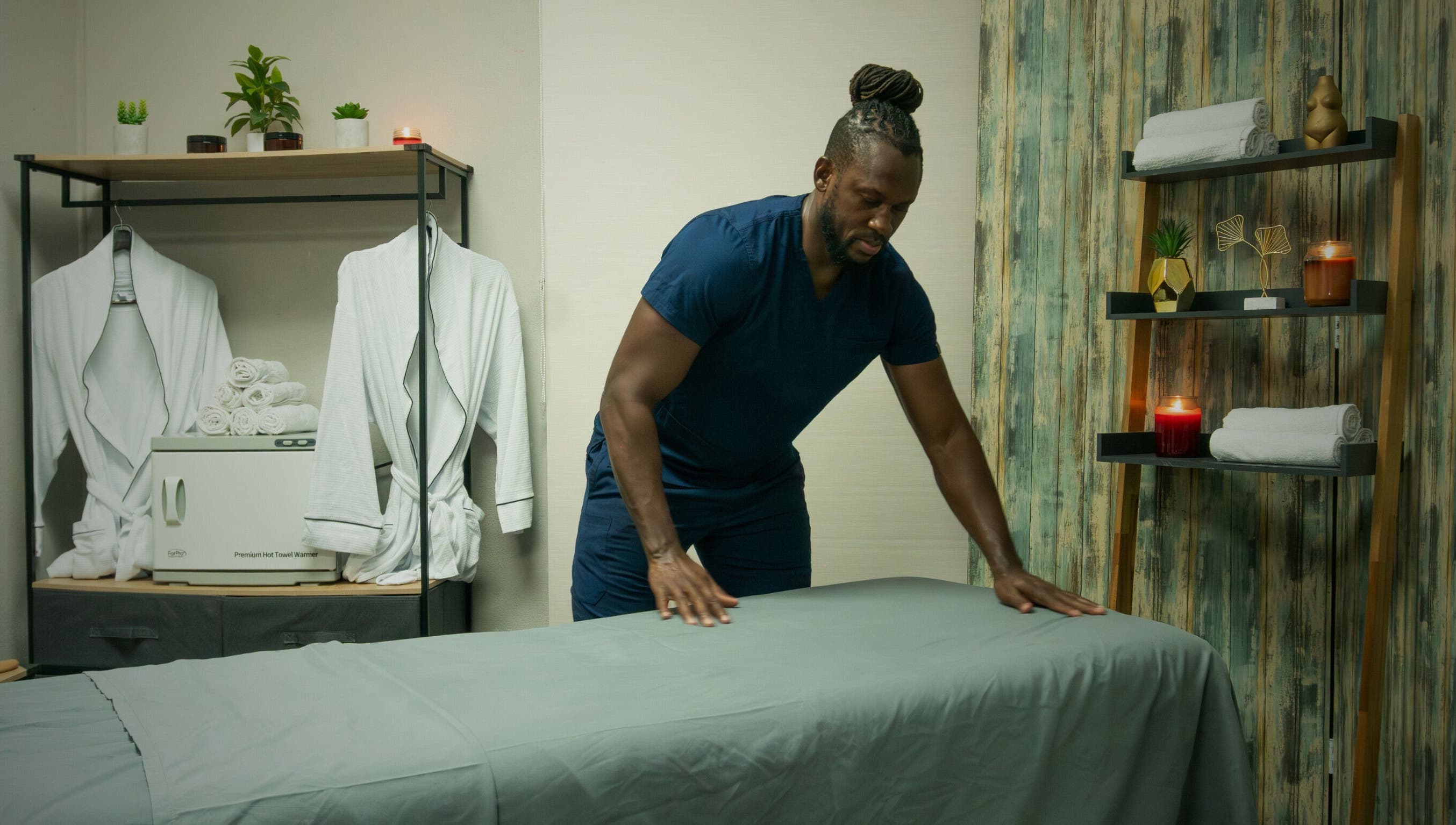 Therapist at Absolute Fitness Active Therapy Lounge in Bridgetown, Saint Michael, BB setting up a relaxing massage room.