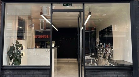 Front view of blanc space salon in Manchester, England, GB featuring sleek glass doors and modern interior.