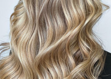 Blonde wavy hairstyle at G R Hair Studio, Truro, England, GB enhancing elegant golden tones.