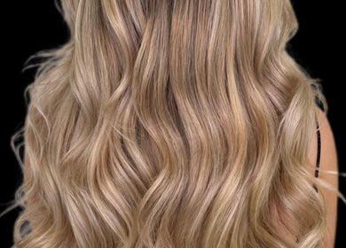 Elegant blonde wavy hairstyle from G R Hair Studio in Truro, England, GB showcases stunning hair design.