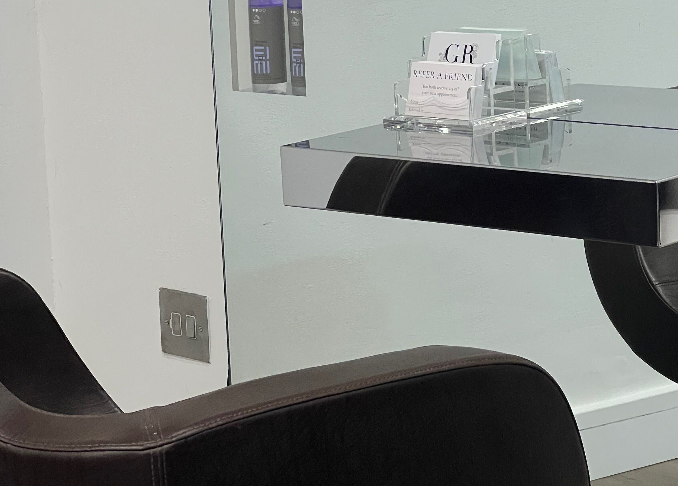 Modern styling chair and mirrored table at G R Hair Studio, Truro, England, GB.