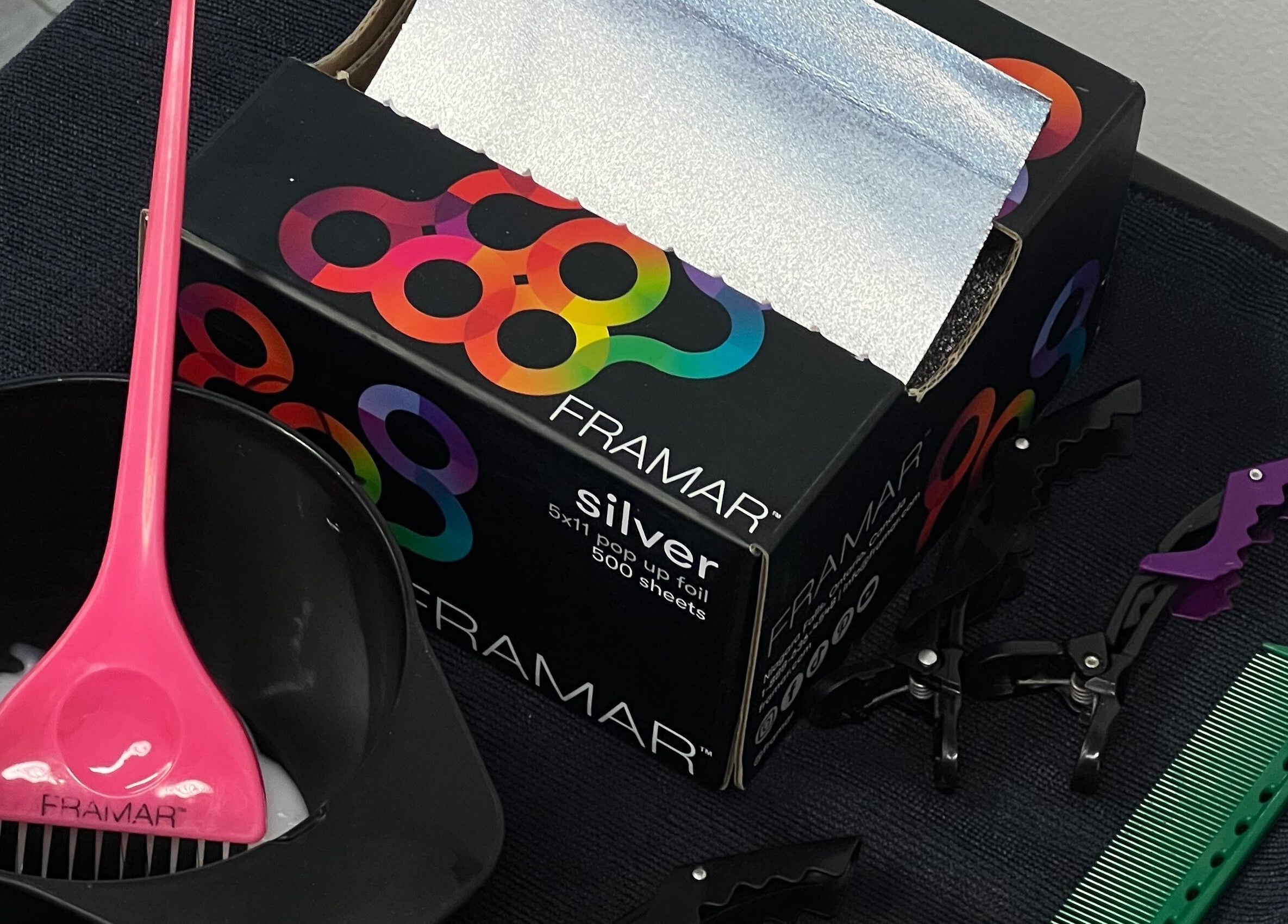 Hair coloring tools at G R Hair Studio, Truro, England, GB include pink brush, foil, clips, and comb.