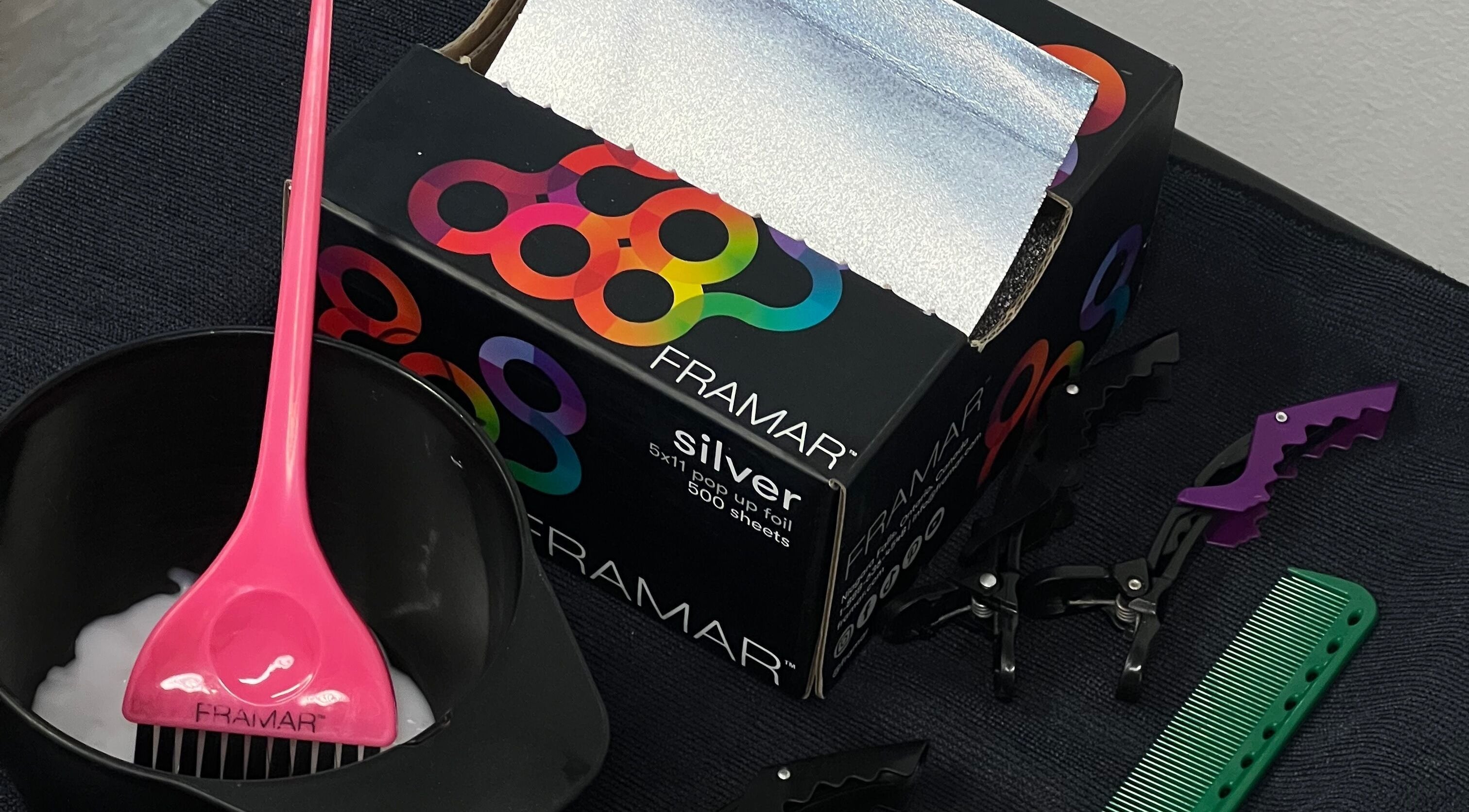 Hair coloring tools at G R Hair Studio, Truro, England, GB include pink brush, foil, clips, and comb.